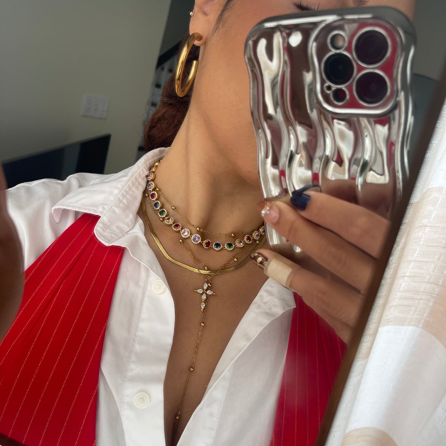 Person wearing gold jewelry with a red and white background