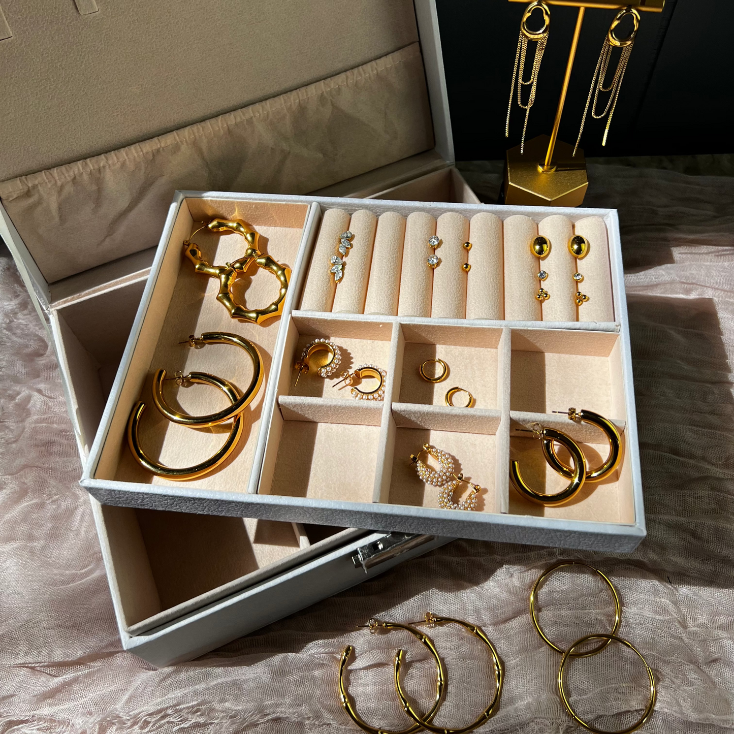 Jewelry set with gold earrings displayed in an open jewelry box.