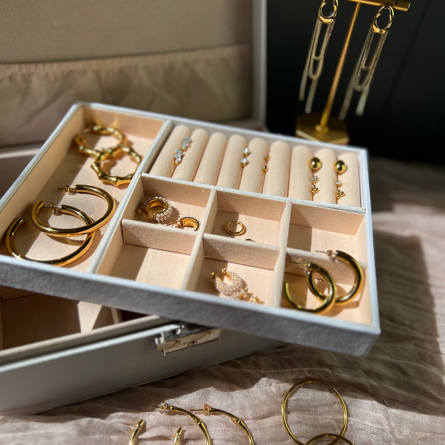 Jewelry box with gold earrings on a textured surface