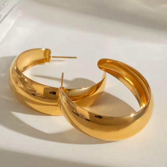 Gold hoop earrings on a white background.