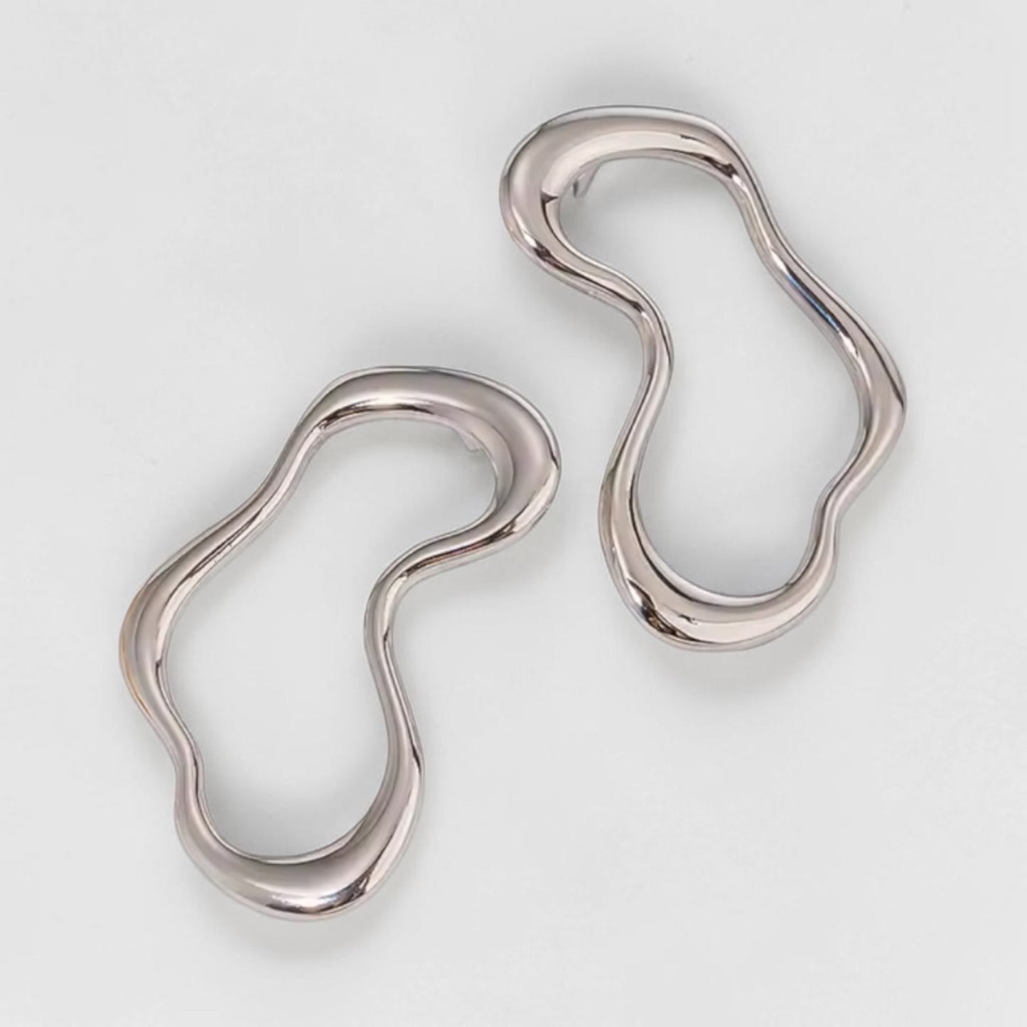 Pair of silver earrings on a light gray background