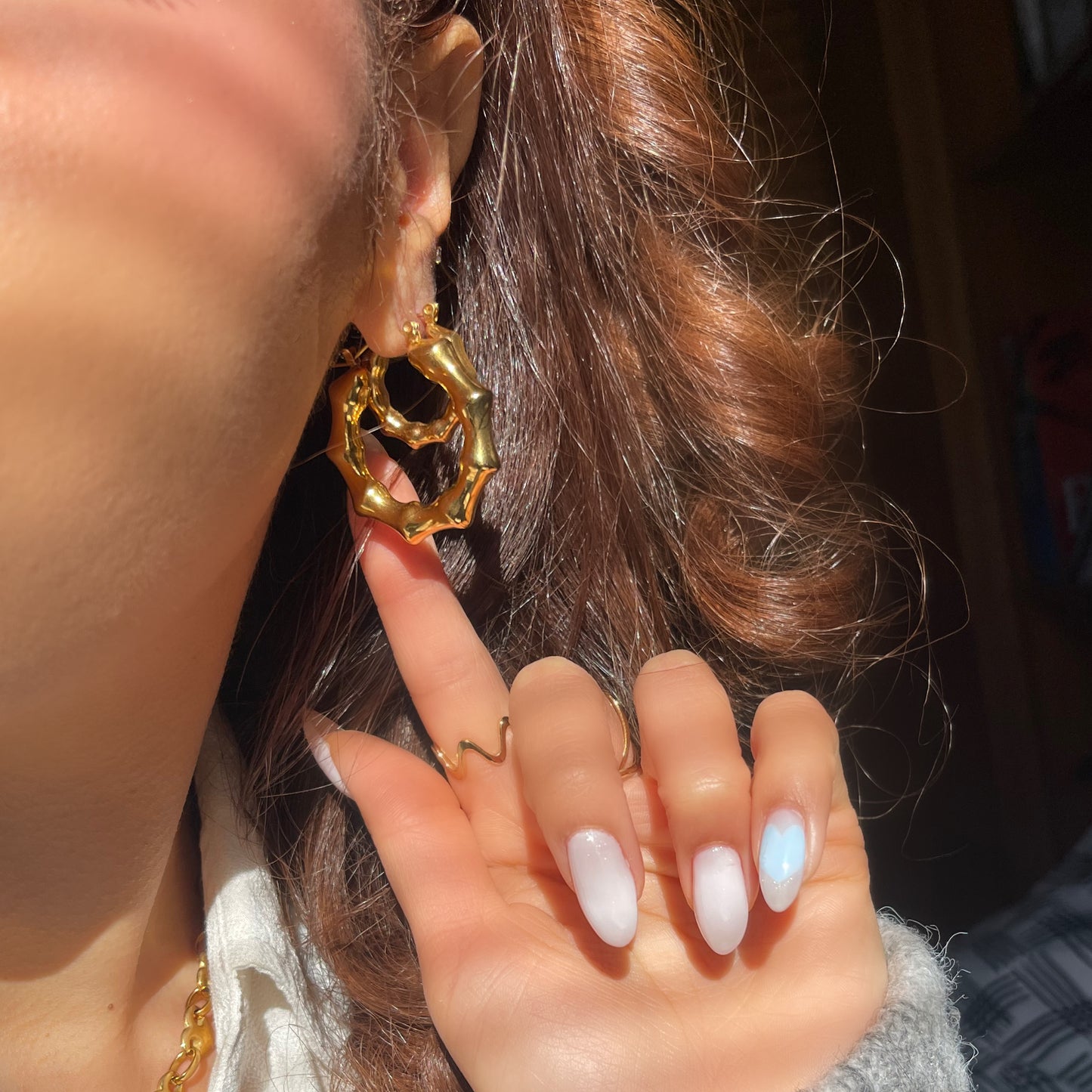 Close-up of a person wearing the Bubble Bamboo Hoop Duo, featuring two gold bamboo-style hoop earrings with a textured, bubbly metallic finish.