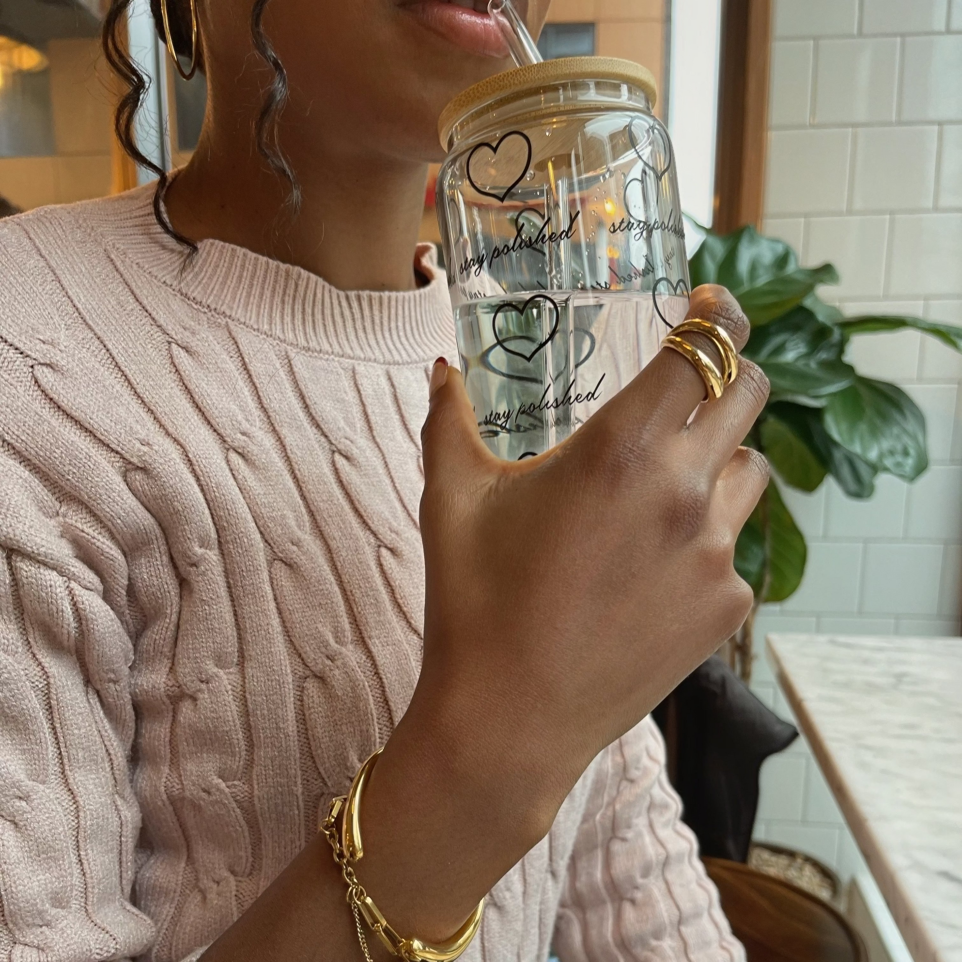 Person holding a glass with a straw in a casual setting