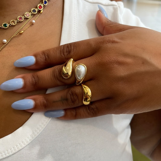 Close-up of a person wearing gold jewelry with a blurred indoor background