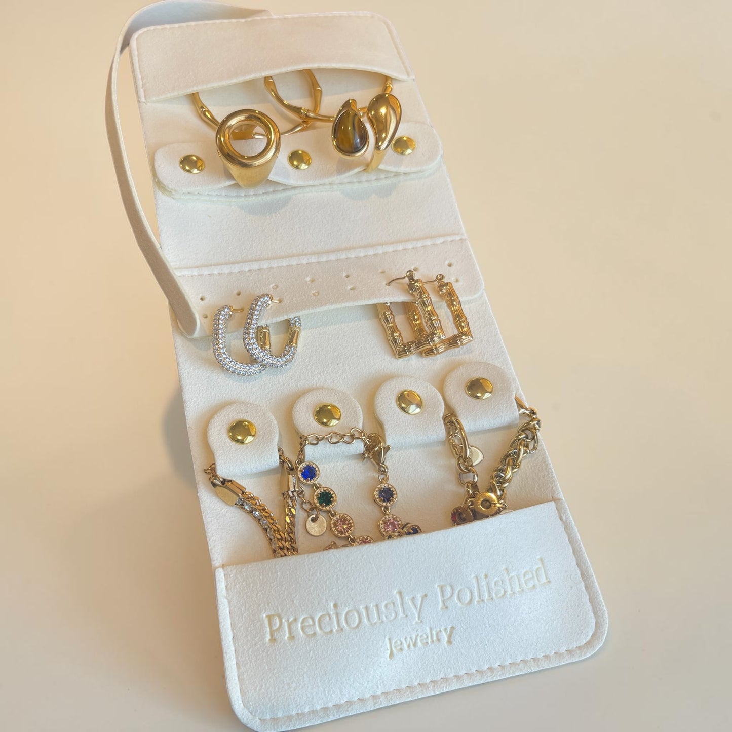 Jewelry organizer with gold jewelry on a beige background
