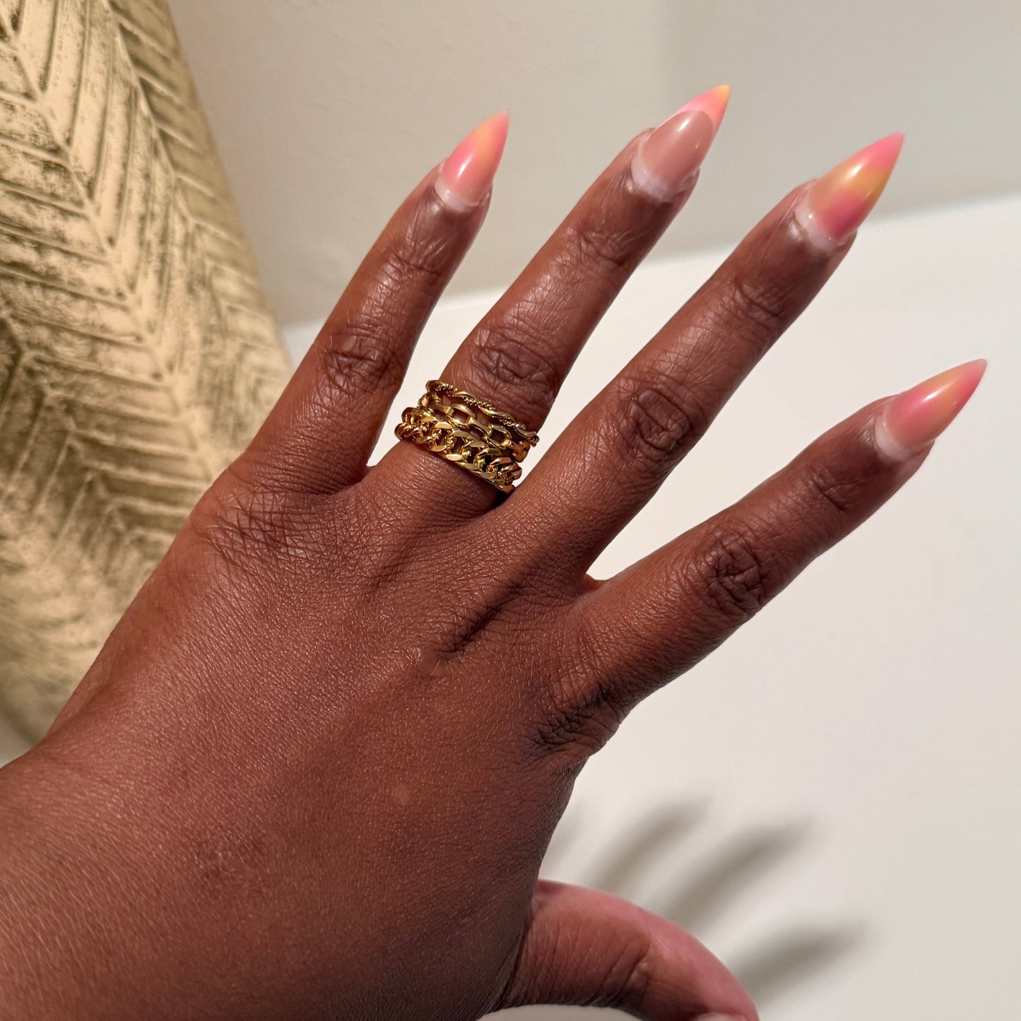 Hand with a gold ring on a neutral background