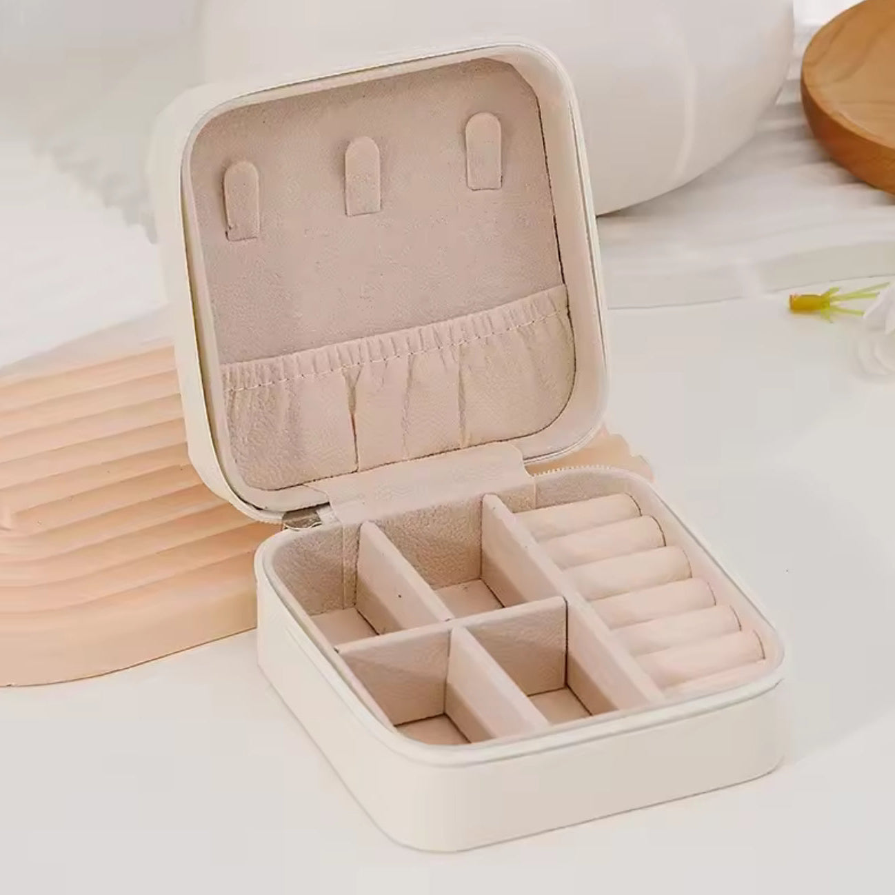 Beige jewelry box with compartments on a light background
