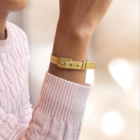 Gold bracelet on a wrist with a pink sweater