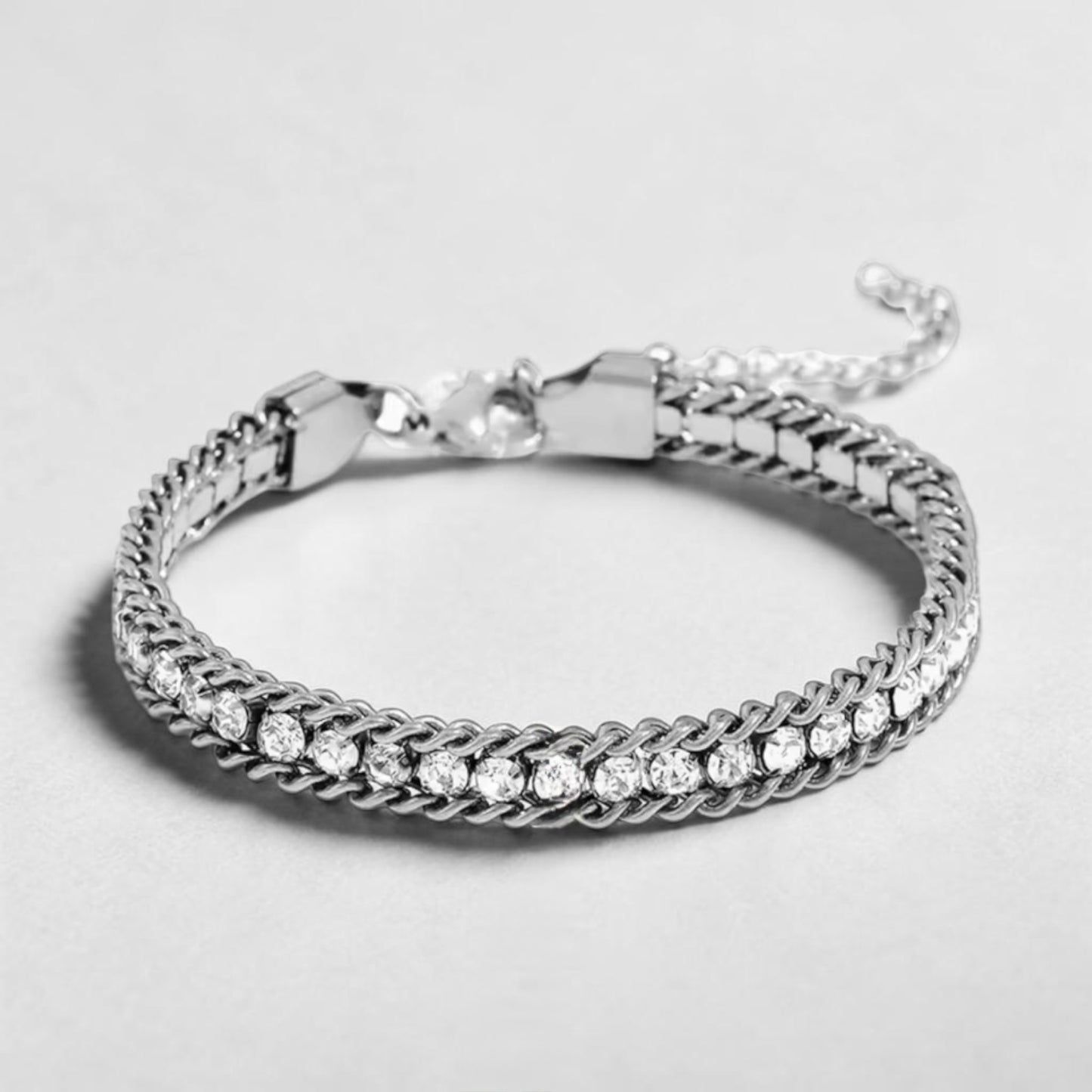 Silver bracelet with diamond accents on a light gray background