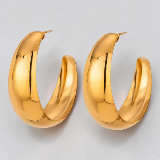 Pair of gold hoop earrings on a light gray background